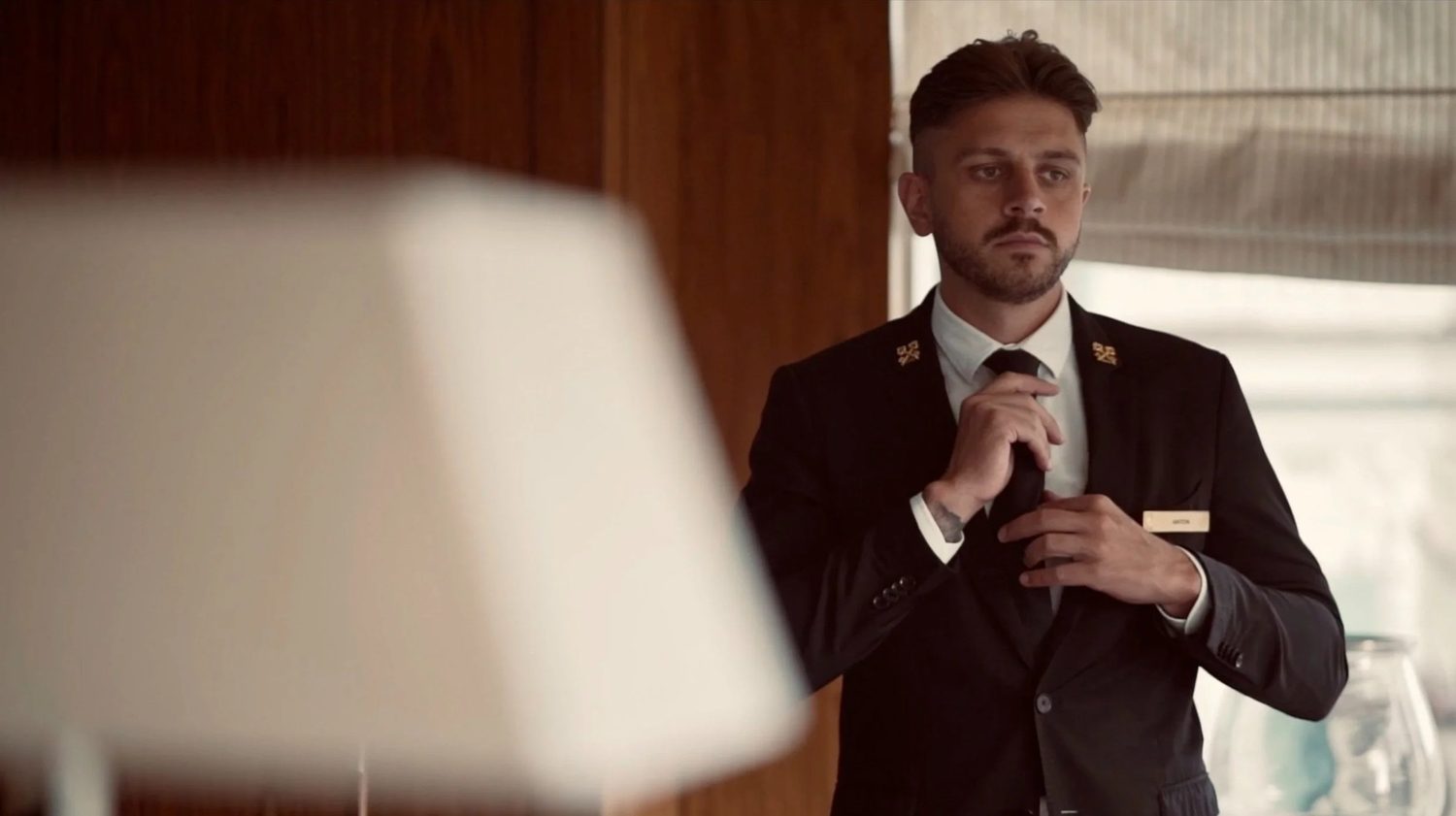 A concierge straightens his jacket before the day